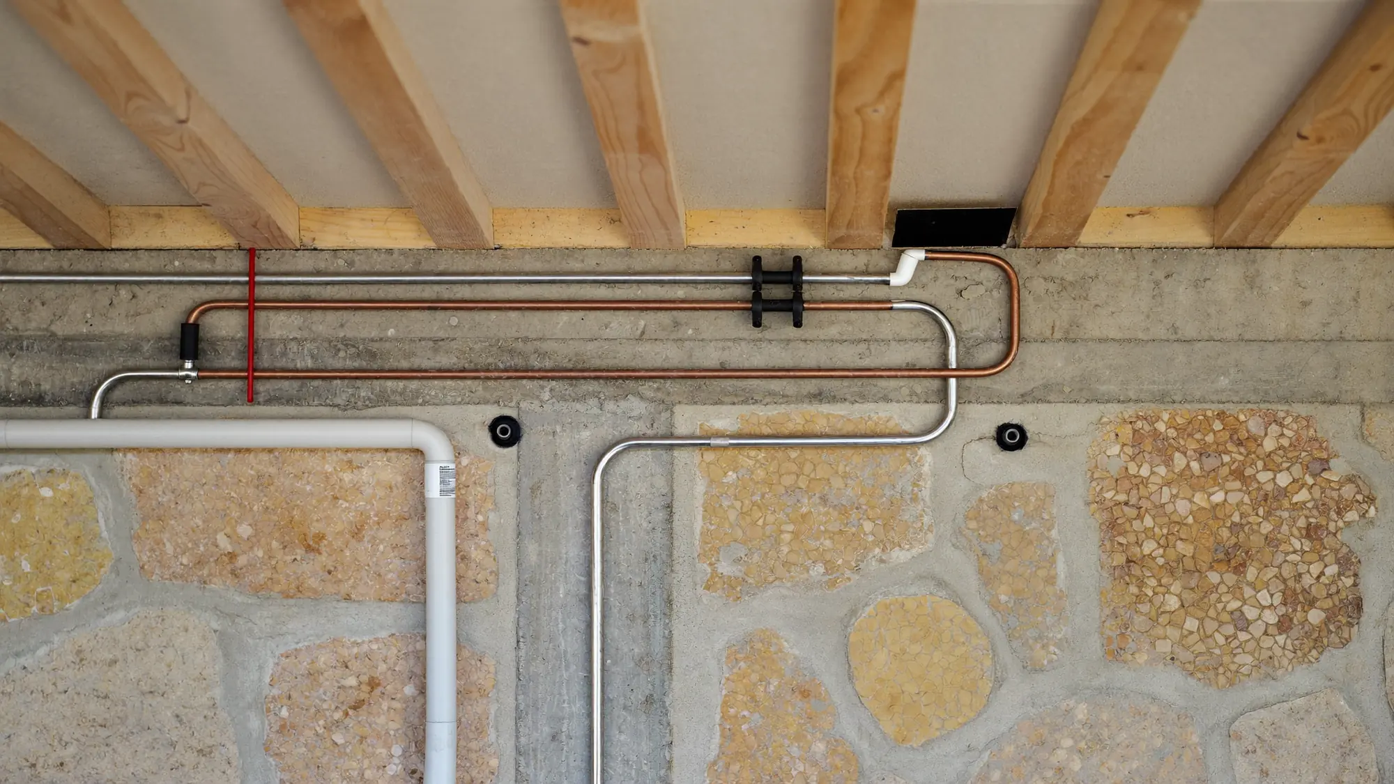 Render orientatiu d'instal·lacions de tubs i conduccions en una paret.