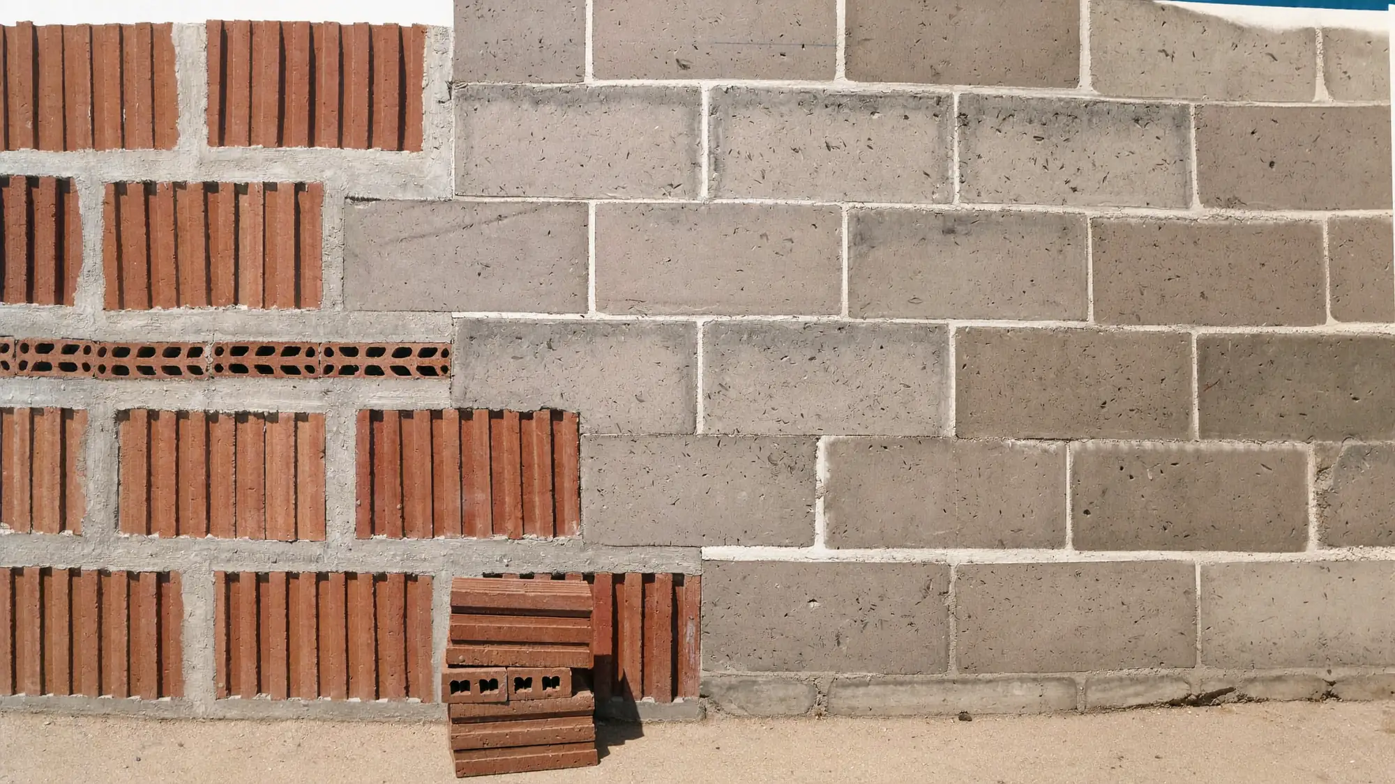 Render orientatiu d'un mur d'obra de maó i bloc en construcció.