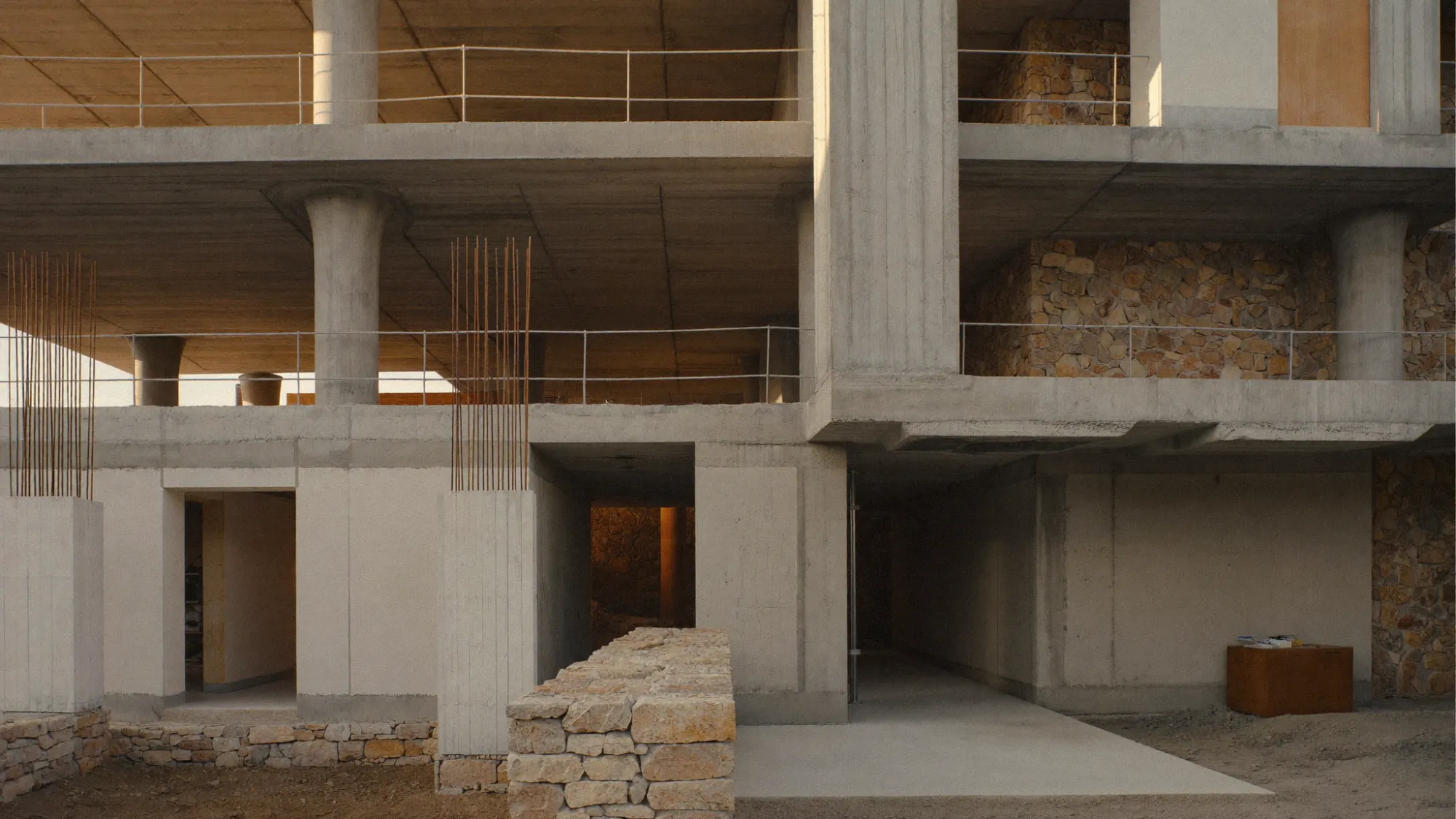 Obra de construcció amb estructura de formigó i llum mediterrània.